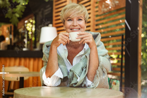 Smiling mature woman wrapped in blanket