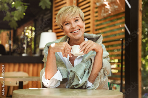 Cheerful mature woman wrapped in blanket photo