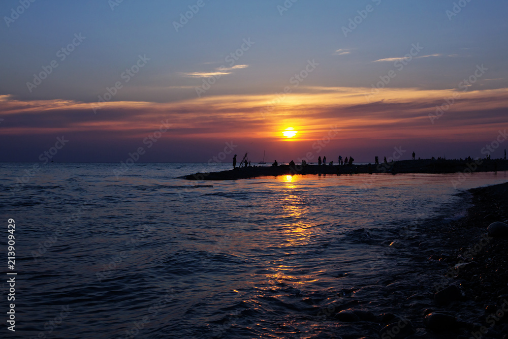 Large crowds of tourists on the black sea in the summer evening.
