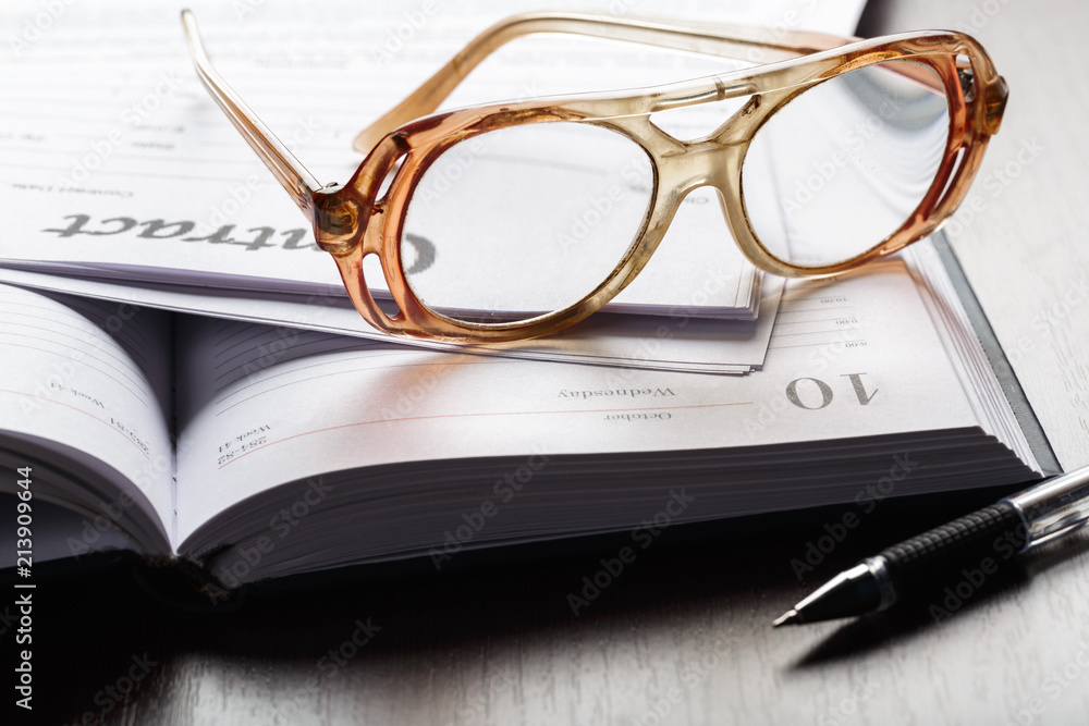 Close up shot of Eyeglasses on contract document papers business concept Close up shot of Eyeglasses on contract document papers business concept