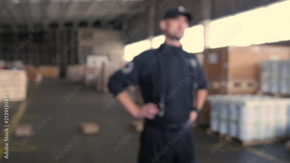 anonymous Polish customs officer talks on the backyard of warehouse anonymous Polish customs officer talks on the backyard of warehouse