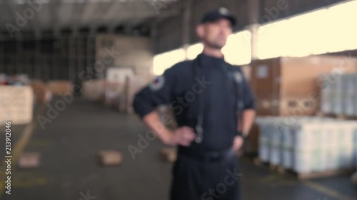 anonymous Polish customs officer talks on the backyard of warehouse
