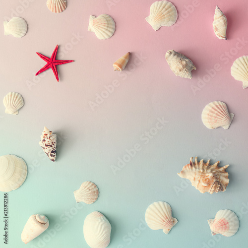 Creative seashell pattern with red starfish on gradient pastel pink and blue background. Summer flat lay.