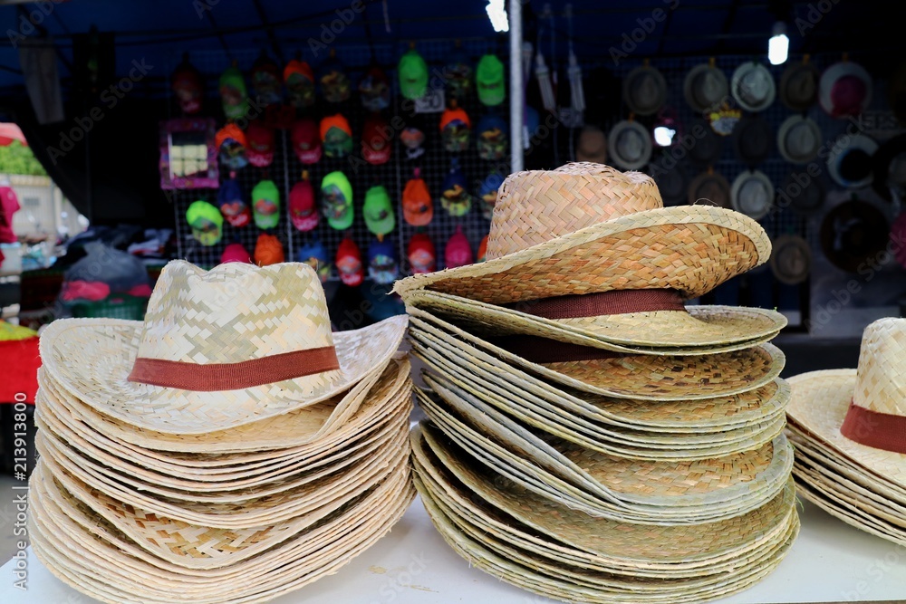 Straw hat for sale in summer time at thai street market. Object and travel concept.