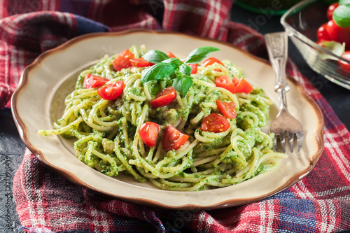 Vegetarian pasta spaghetti with basil pesto and cherry tomatoes