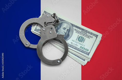 France flag  with handcuffs and a bundle of dollars. Currency corruption in the country. Financial crimes