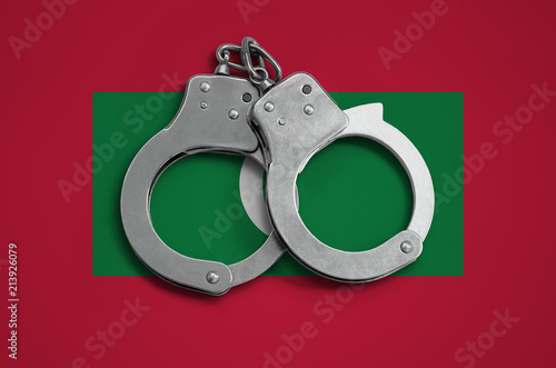 Maldives flag  and police handcuffs. The concept of observance of the law in the country and protection from crime photo