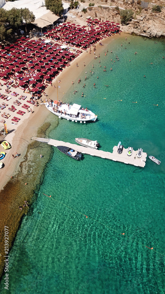 Aerial drone, bird's eye view photo of iconic and famous crowded beach of Super Paradise with sapphire clear waters, Mykonos island, Cyclades, Greece