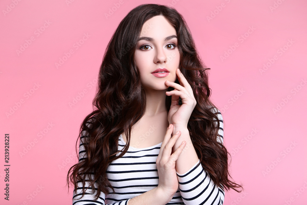 Portrait of young woman in striped blouse on pink background Portrait of young woman in striped blouse on pink background