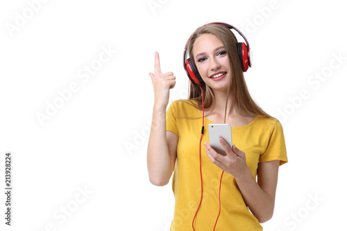 Young woman with headphones and smartphone on white background