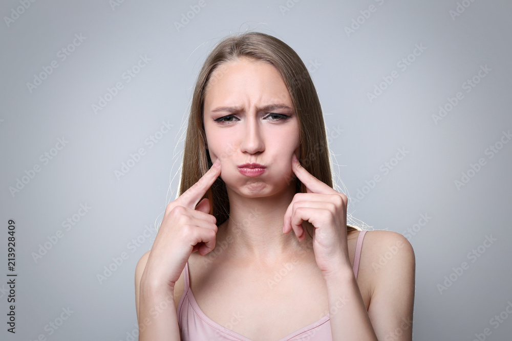 Portrait of young woman on grey background Portrait of young woman on grey background