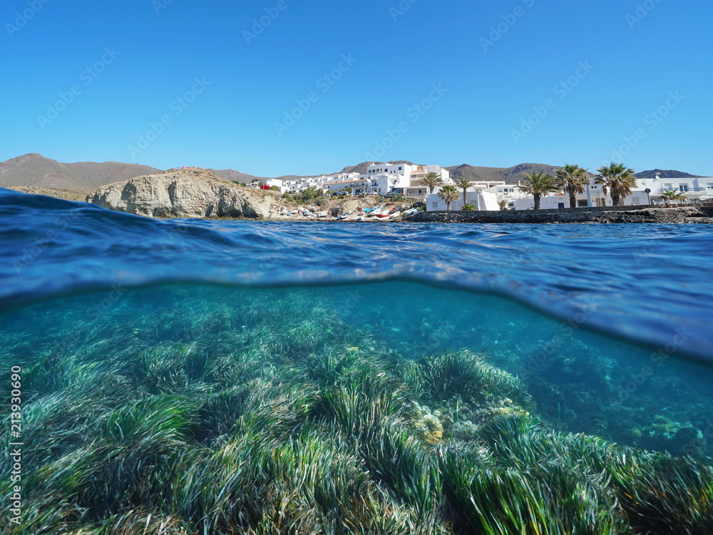 Typical fishing village La Isleta del Moro on the Mediterranean coast with seagrass underwater sea, split view above and below water surface, Cabo de Gata-Níjar, Almeria, Andalusia, Spain