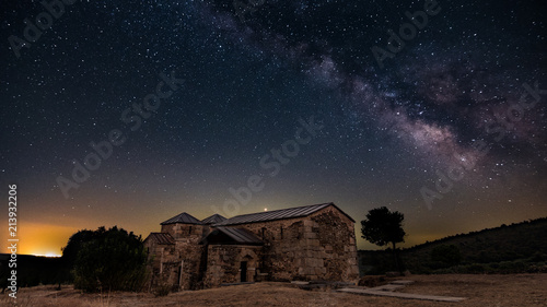 Night view of Santa Lucia del Trampal in Alcuéscar (Spain) with Milky Way Galaxia photo
