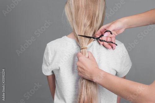 Professional stylist cutting off woman's hair, Female hairdresser hold in hand blonde hair, comb and scissors closeup. Keratin restoration, latest trend, fresh idea, instrument store concept