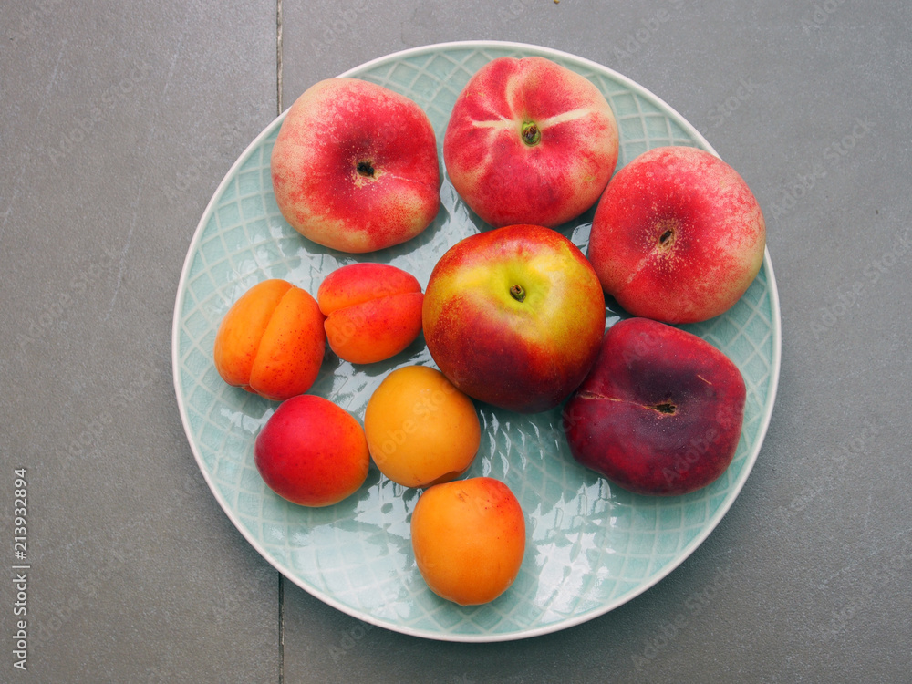 Sommerlicher Obstteller mit Aprikosen, Pfirsichen und Äpfeln Sommerlicher Obstteller mit Aprikosen, Pfirsichen und Äpfeln