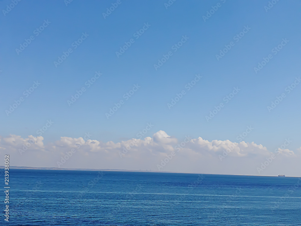 background of beautiful blue black sea under fluffy white clouds under the blue sky