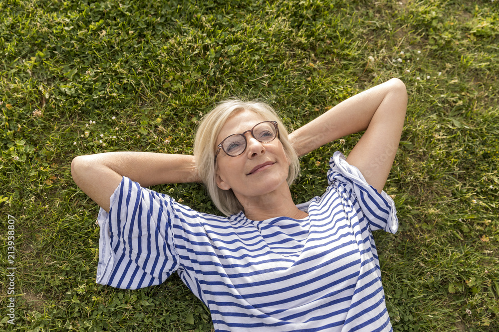 Portrait of smiling senior woman lying in grass Portrait of smiling senior woman lying in grass