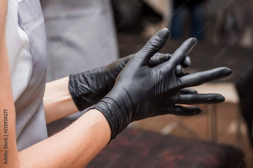 woman dresses black gloves on her hands, shugaring
