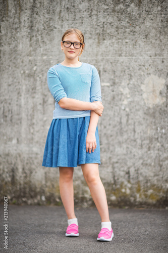 Outdoor portrait of pretty young kid girl wearing eyeglasses