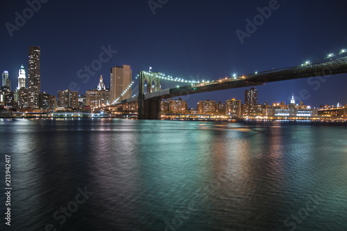 Colourful city lights at night from Brooklyn Bridge in New York City