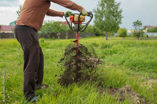 Worker drills the ground at the construction site
