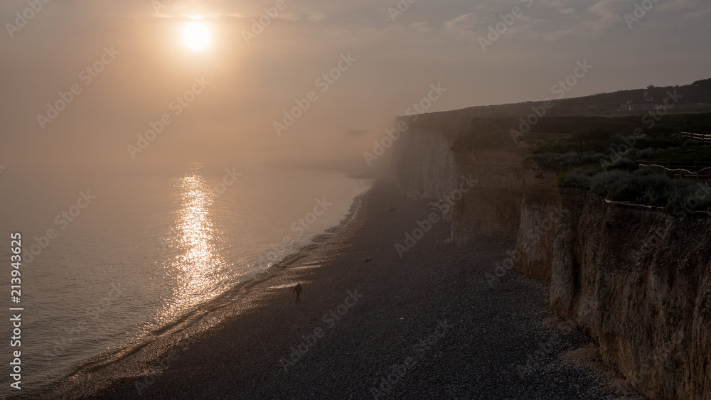 Foggy Seven Sisters Cliffs coast landscape in England at sunset