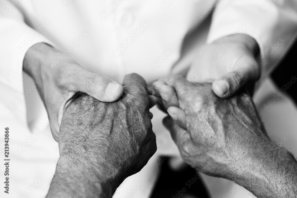 Fototapeta premium man holding the hands of a senior man