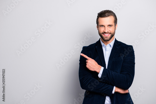 Portrait of cheerful excited joyful satisfied handsome attractive fashionable macho guy dressed in formal outfit dark velvet pointing on empty blank copyspace isolated on gray background copy-space
