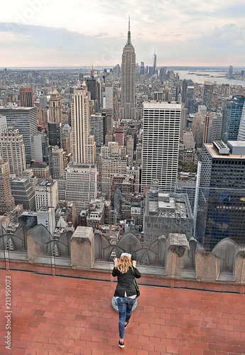 young woman watching a new york cityscape and skyline Rockefeller Center Observatory in manhattan in new york, USA