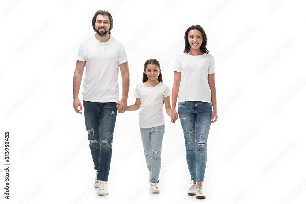 smiling family in white shirts and jeans holding hands while walking together isolated on white smiling family in white shirts and jeans holding hands while walking together isolated on white