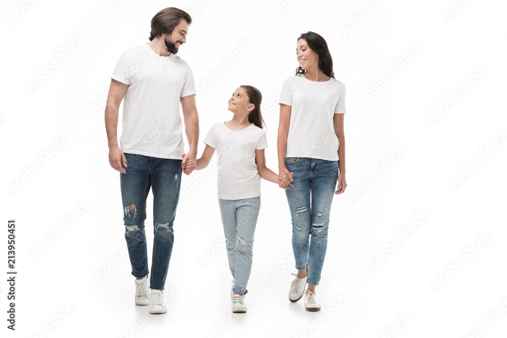 smiling family in white shirts and jeans holding hands while walking together isolated on white smiling family in white shirts and jeans holding hands while walking together isolated on white