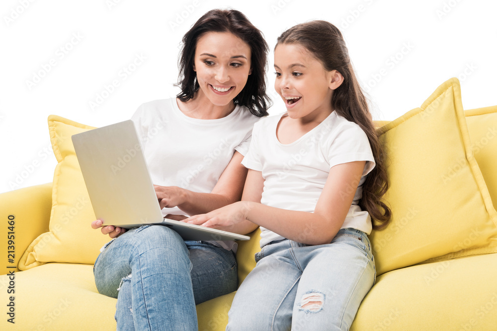 portrait of mother and happy daughter using laptop together on sofa isolated on white portrait of mother and happy daughter using laptop together on sofa isolated on white