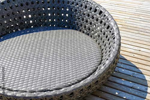 Rattan table and chaise longues near modern swimming pool, closeup photo