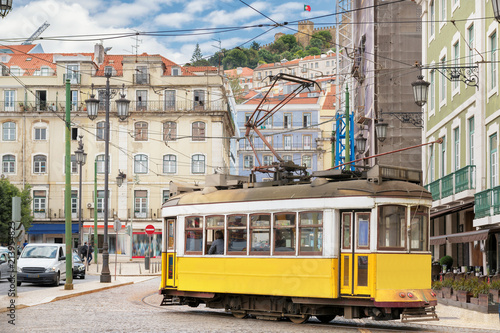 Vintage Yellow tram in the city center of Lisbon in a beautiful summer day, Lisbon, Portugal.