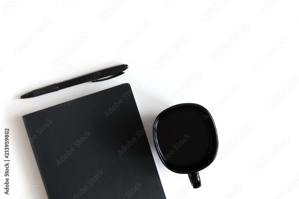 Workspace, white office table, black notebook on white background, pen, cup coffee. Travel vacation concept. Flat lay, top view, copy space Workspace, white office table, black notebook on white background, pen, cup coffee. Travel vacation concept. Flat lay, top view, copy space