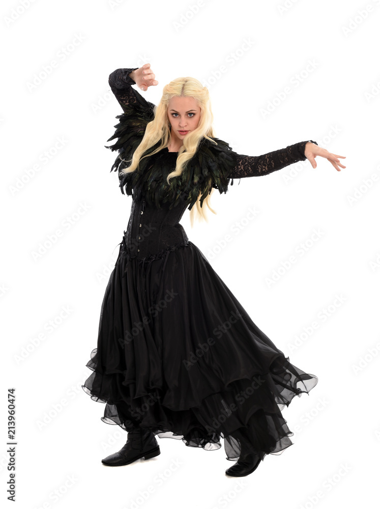 full length portrait of blonde girl wearing corset and long black gown. isolated on white studio background,