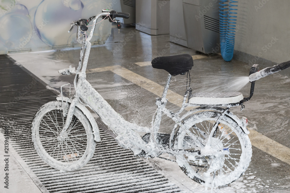 Washing an electric bicycle with a jet of foam in a car wash Washing an electric bicycle with a jet of foam in a car wash
