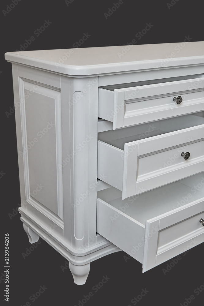 White wooden chest of drawers isolated on dark grey White wooden chest of drawers isolated on dark grey