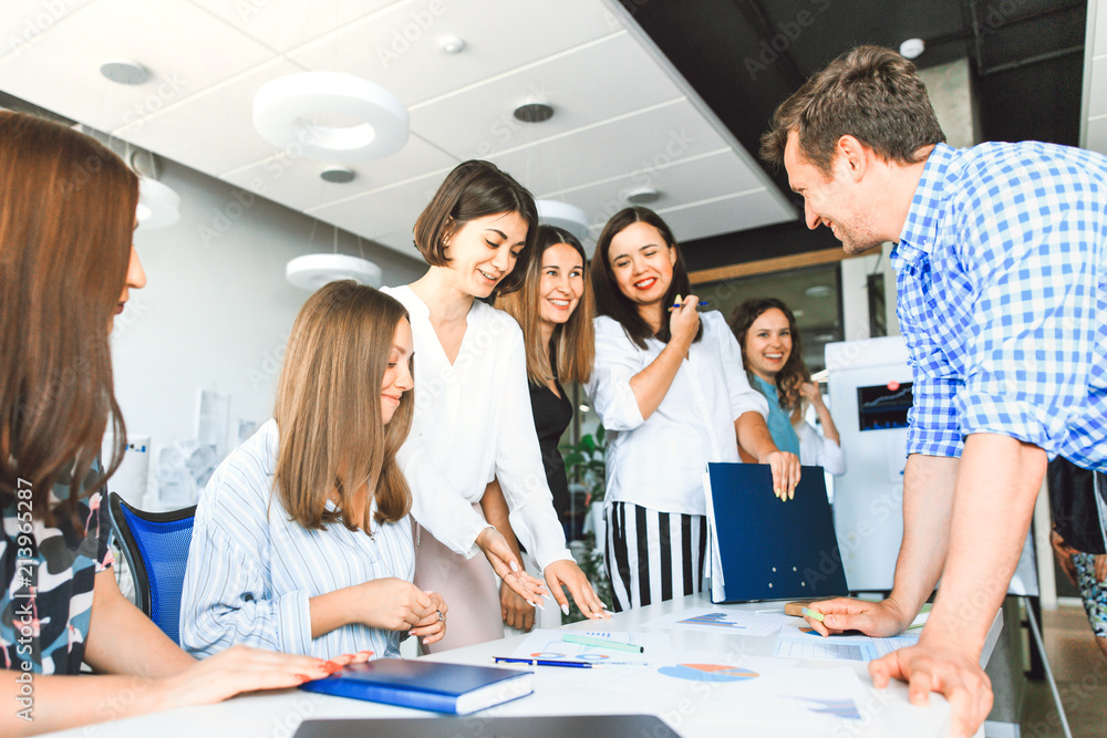 Business team in casual clothes confer at a table in the office Business team in casual clothes confer at a table in the office