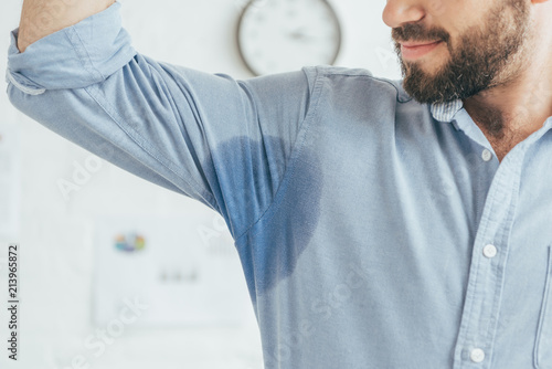 Canvas-taulu cropped view of sweaty businessman showing blue wet shirt