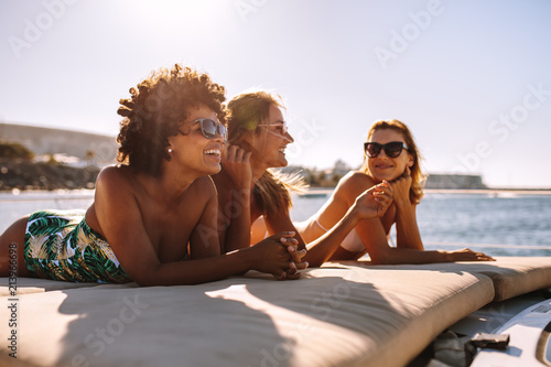Three young women sunbathing on yacht