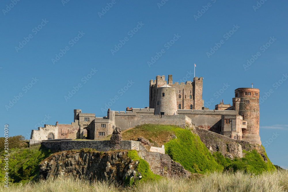Bamburgh Castle behind the remains of a windmill Bamburgh Castle behind the remains of a windmill
