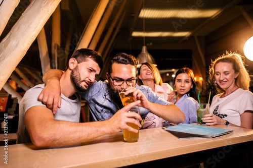 Canvas Print Drunk friends at the bar drinking beer celebrating a bachelor party