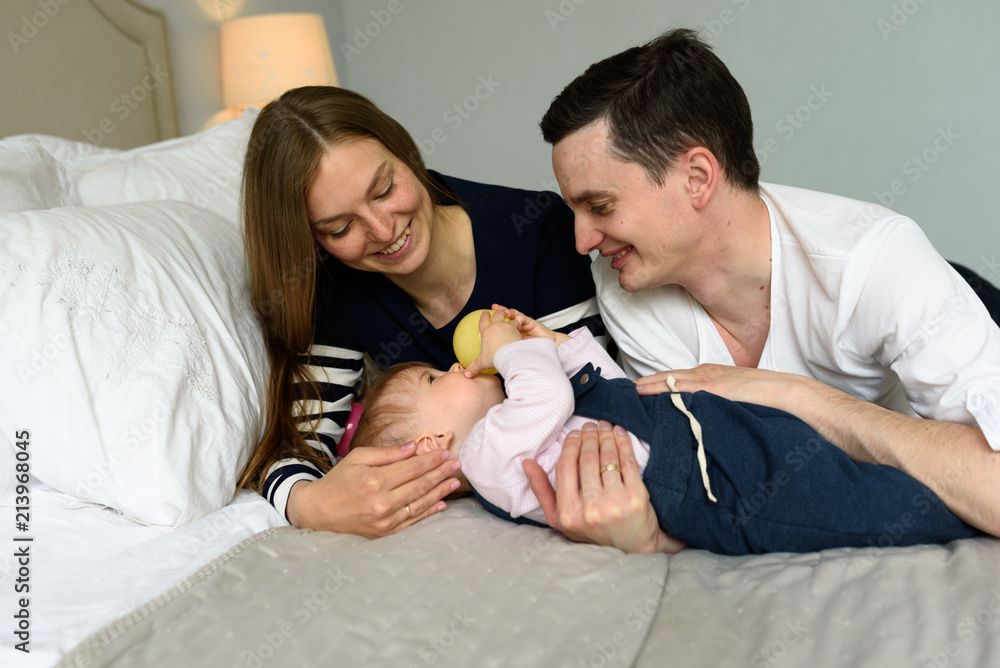 Happy parents playing with child at home Happy parents playing with child at home
