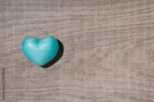 Blue heart shape over wooden table. Symbol of valentine day for background use. Concept of love and romance.