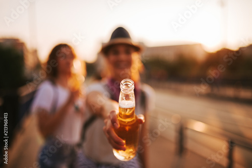 Girl offering a drink or toasting Fotobehang