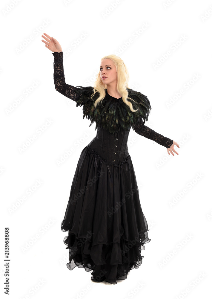 full length portrait of blonde girl wearing corset and long black gown. isolated on white studio background, full length portrait of blonde girl wearing corset and long black gown. isolated on white studio background,