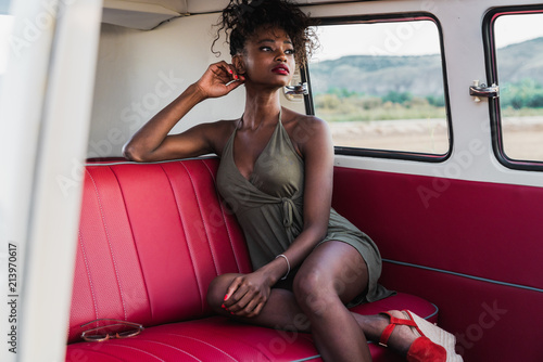 Gorgeous black woman sitting on back seat of van