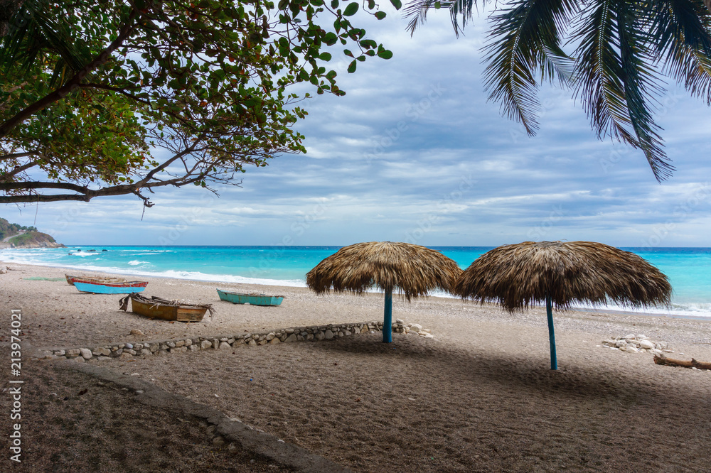 sandy beach with umbrellas near the azure Caribbean sea