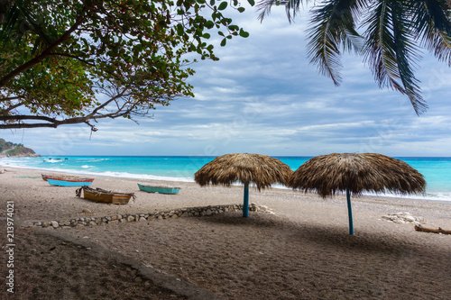 Fototapeta Naklejka Na Ścianę i Meble -  sandy beach with umbrellas near the azure Caribbean sea